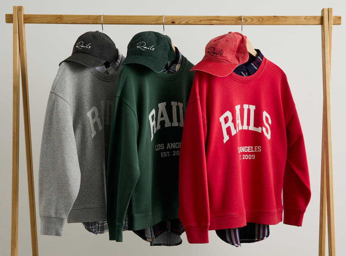 EDITORIAL IMAGE OF THREE ANNIVERSARY SWEATSHIRTS HANGING ON A CLOTHING RACK