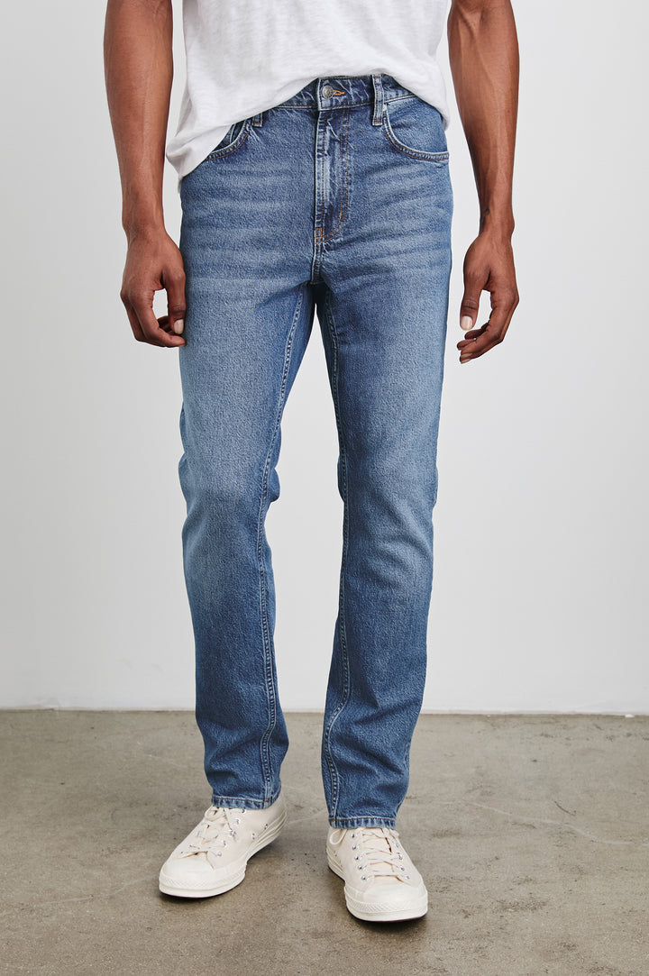 Clayton Slim Straight Jeans with Belt Loops, Two Front Pockets plus a Coin Pocket and Two Back Patch Pockets in Authentic 10 Year Colorway, a Blue - Front View Featured on Model