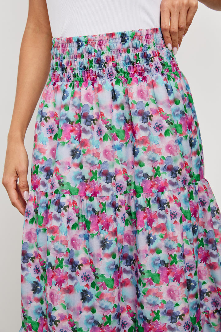 Edina Tiered Midi Skirt with Shirred High-Rise Waistline in Spring Floral Colorway, with mostly pinks and purples - Front View Featured on Model