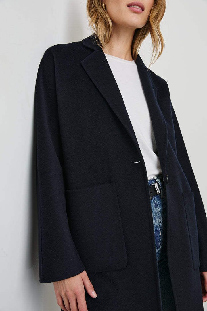 Everest Mid-Thigh Length Coat with Single Button Closure, Notched Lapels and Front Patch Pockets in Navy Colorway - Front View Featured on Model