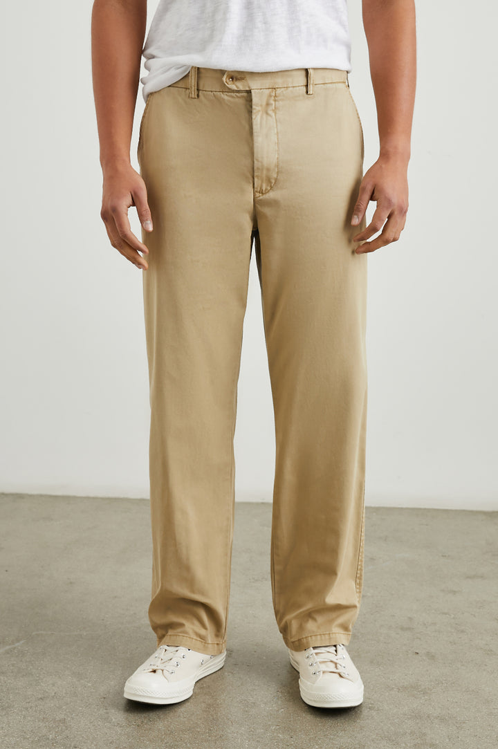 Garrett Pants with a Button Strap Closure at the Waist, Belt Loops, Two Front Pockets and Two Back Button Welt Pockets in True Khaki Colorway - Front View Featured on Model