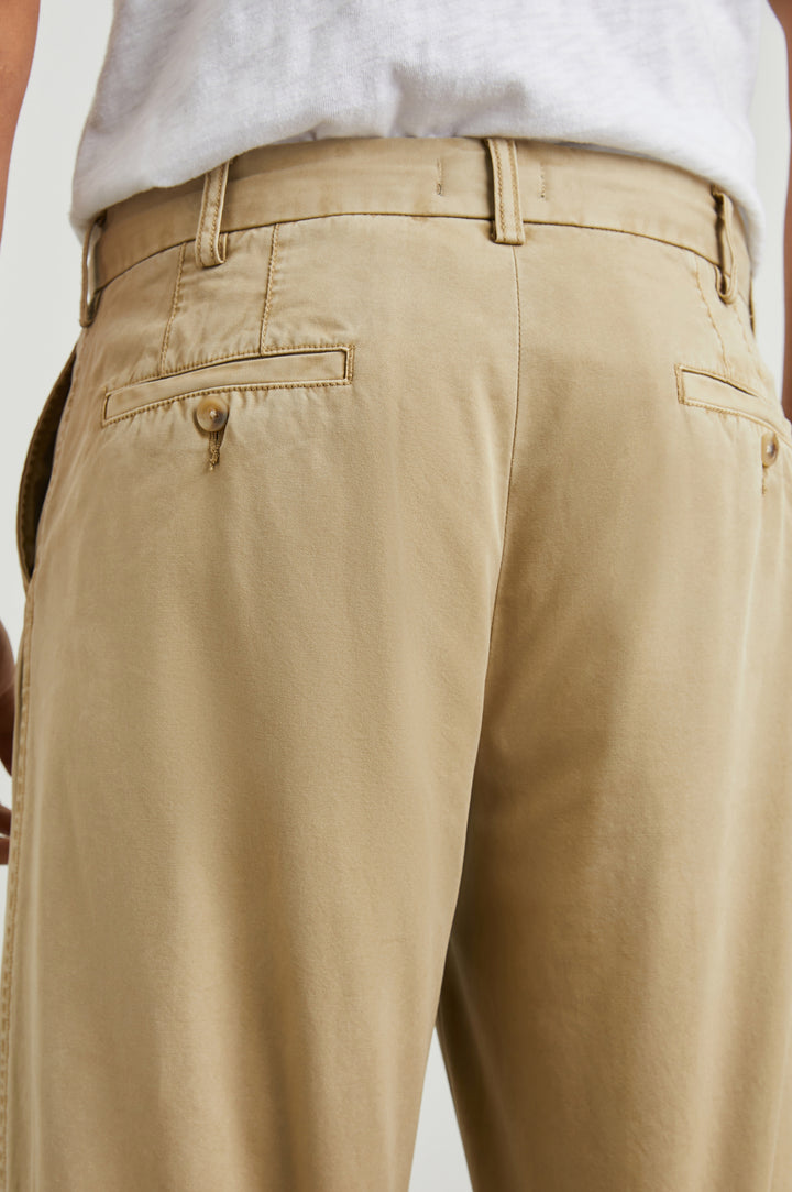 Garrett Pants with a Button Strap Closure at the Waist, Belt Loops, Two Front Pockets and Two Back Button Welt Pockets in True Khaki Colorway - Back View Featured on Model