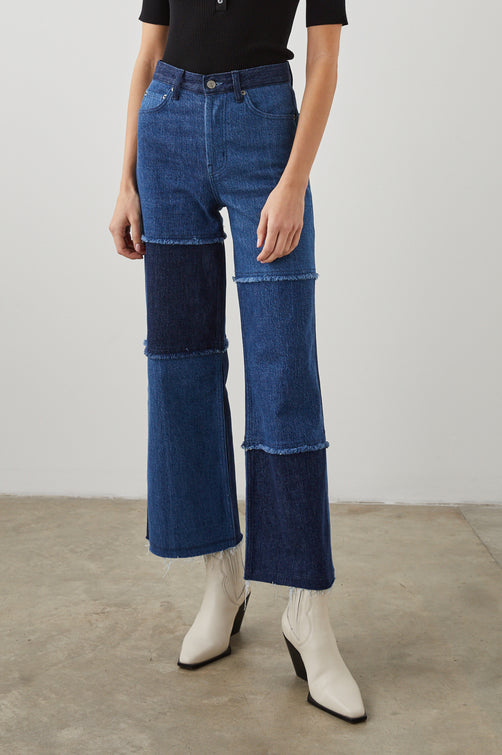 Getty Crop Wide Leg Denim Pants with Belt Loops, Two Front Pockets and Two Back Patch Pockets in Indigo Patchwork Colorway, with large patches in blues - Front View Featured on Model