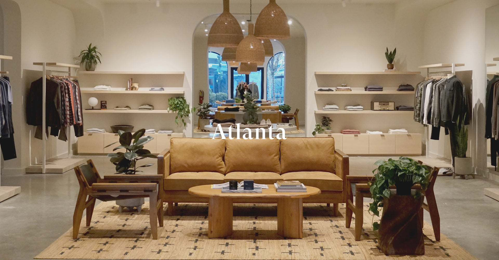 INSIDE OF ATLANTA STORE SHOWING A COUCH WITH TWO CHAIRS SURROUNDED BY CLOTHING RACKS