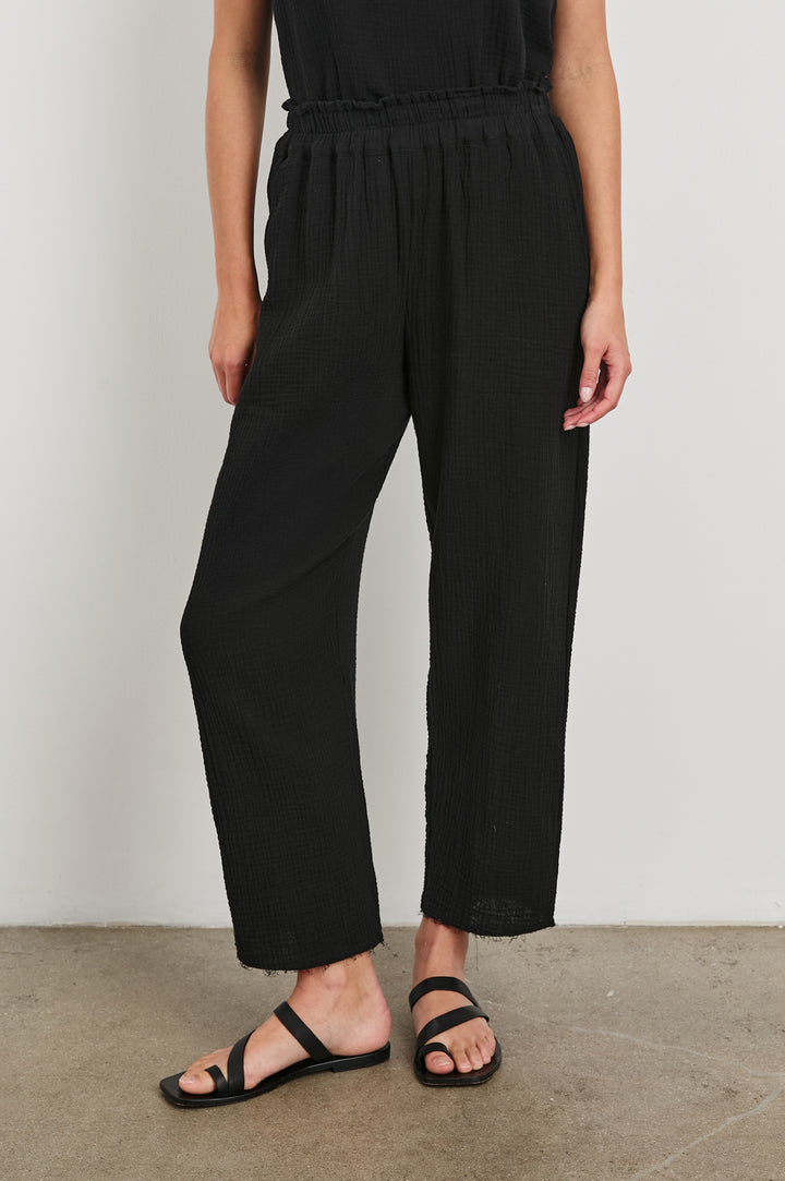 Leon Crop Cotton Gauze Pant With Hemline Slit And Elastic Waist In Colorway Black - Front View Featured On Model