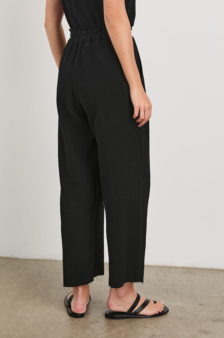 Leon Crop Cotton Gauze Pant With Hemline Slit And Elastic Waist In Colorway Black - Back View Featured On Model