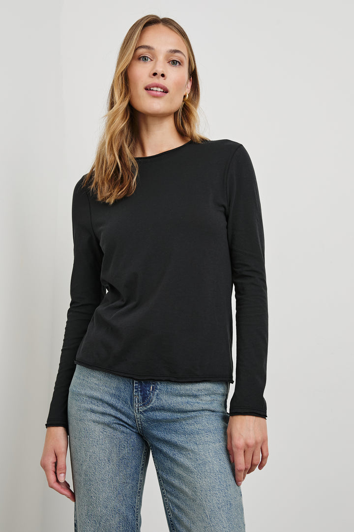 Long Sleeve Crew Neck T Shirt with Raw Hem, Collar and Cuffs in Black Colorway - Front View Featured on Model