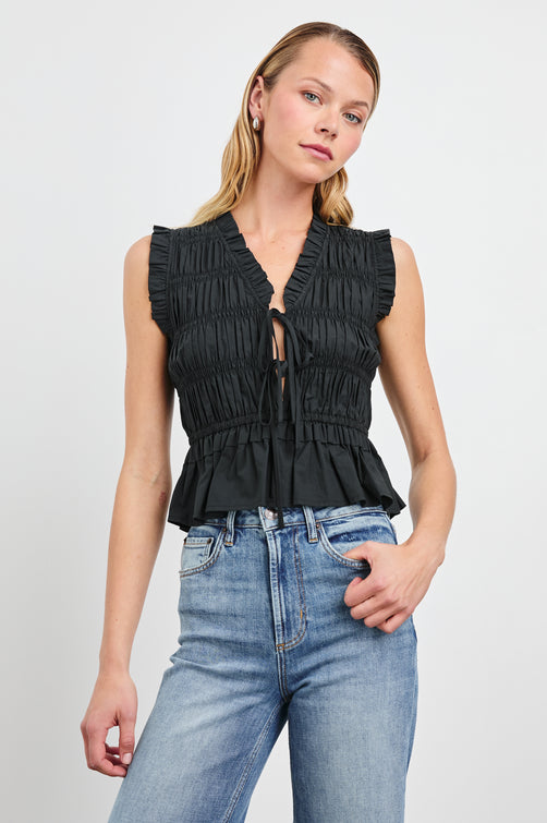 Martine Sleeveless Top with Ruffled Trim, a Deep V-Neck with Ties and Smocking in Black Colorway - Front View Featured on Model 