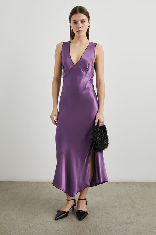 Monique Sleeveless Midi Dress with an Asymmetrical Hem Line, Side Slit, Deep V Neck, and Wide Shoulder Straps in Amethyst Colorway - Front Full Body View Featured on Model