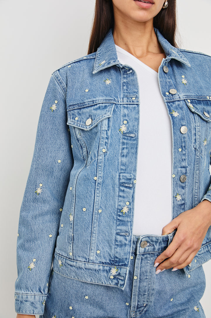 Mulholland Indigo Trucker Style Denim Jacket with 2 Front Pockets, Front Buttons, and Daisy Embroidery Details - Front View on Model with Close up of Embroidery Details