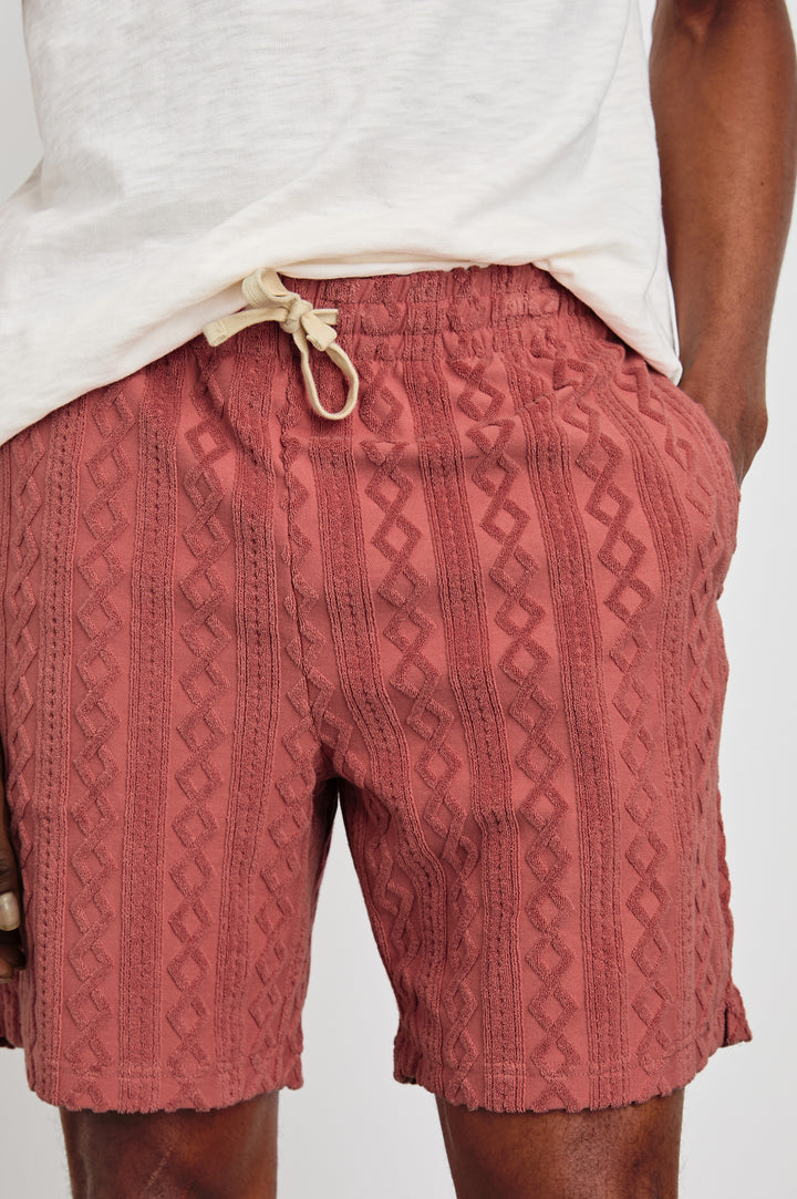 Nova terry shorts with raised jacquard pattern and front drawstring in Faded Red - close up of details on model