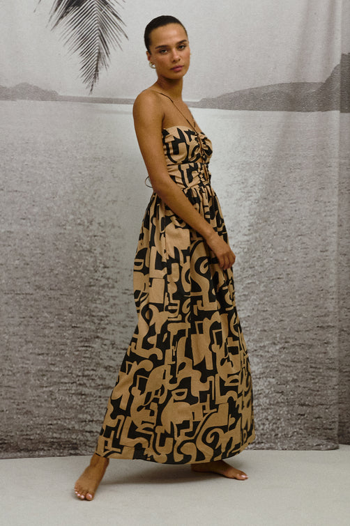 Silvia Dress, tan and black pattern in Santorini Sand with skinny straps and front cutouts - front view on model in motion