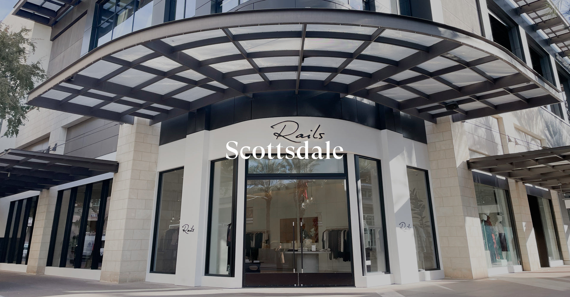 OUTSIDE OF SCOTTSDALE STORE SHOWING THE FRONT ENTRANCE (TWO LARGE GLASS DOORS) WITH RAILS SIGN ABOVE THE ENTRANCE (RAILS IS WRITTEN IN BLACK CURSIVE LETTERS)